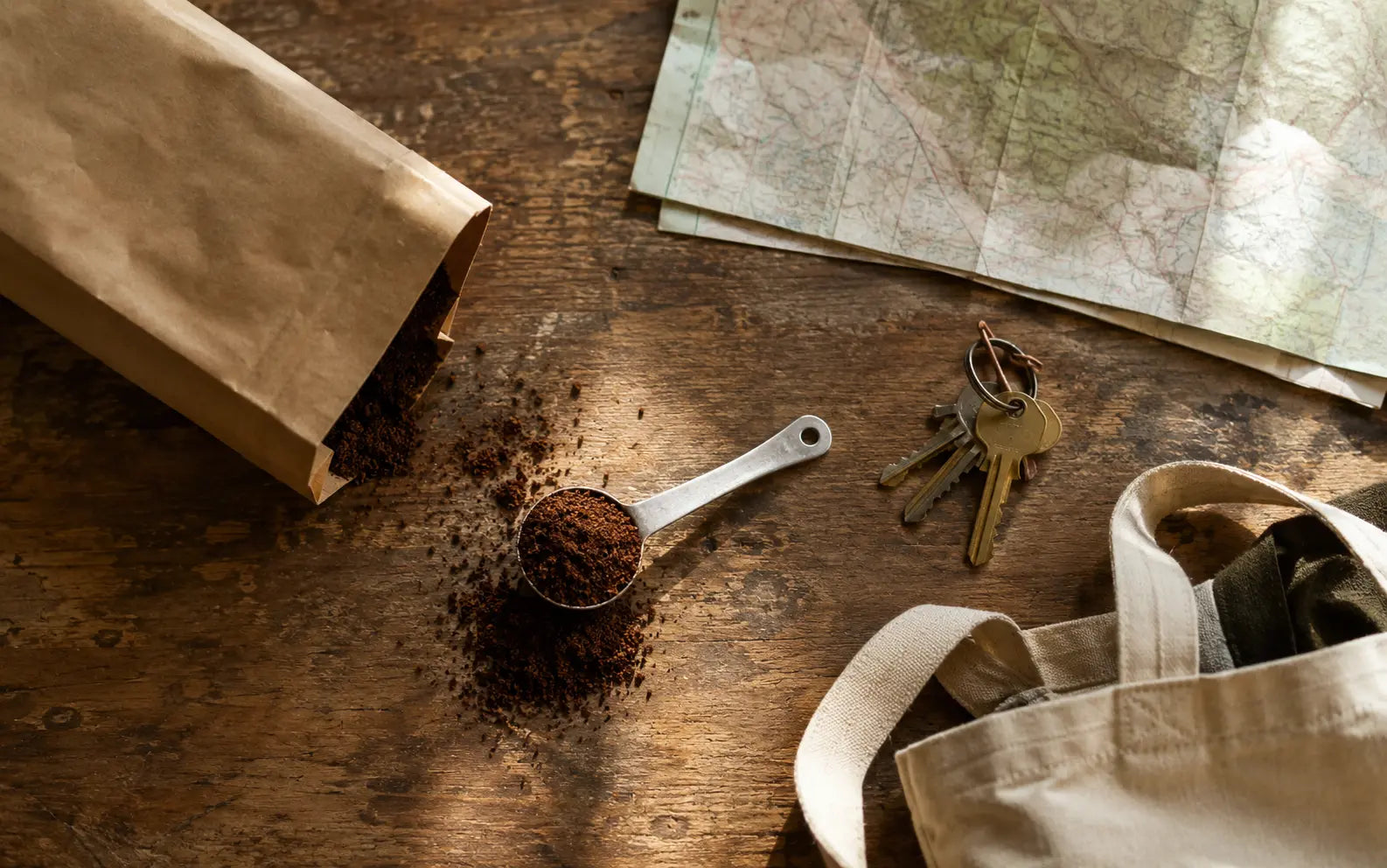 Coffee grounds and travel essentials on a wooden table